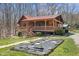 Beautiful log cabin featuring a red metal roof, covered porch, and landscaped garden area at 6351 Dixon Rd, Columbus, IN 47201