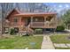 Charming log cabin with a red roof and inviting covered porch at 6351 Dixon Rd, Columbus, IN 47201