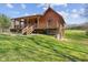 Log cabin with a red metal roof and covered porch, complemented by a well-maintained lawn at 6351 Dixon Rd, Columbus, IN 47201