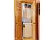 Efficient laundry closet with stacked washer and dryer, and natural wood doors at 6351 Dixon Rd, Columbus, IN 47201