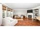 Bright living room featuring a fireplace, comfortable seating, and large windows with woven shades at 6379 Fairfield St, Whitestown, IN 46075
