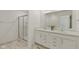 Bright bathroom features double sinks, modern vanity and a tiled shower with glass door at 6476 W Mulberry Way, Greenfield, IN 46140