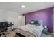 Bedroom featuring a queen-sized bed and a desk area, with purple accent wall at 6476 W Mulberry Way, Greenfield, IN 46140