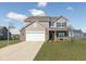Daytime view of a two-story home featuring a basketball hoop, brick accents, and a well-maintained front yard at 6476 W Mulberry Way, Greenfield, IN 46140