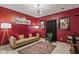 Stylish living room featuring a tan couch, accent rug, and vibrant red walls at 6476 W Mulberry Way, Greenfield, IN 46140