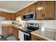 Functional kitchen features wood cabinets, stainless steel appliances, including a microwave and electric cooktop at 676 Nelson Dr, Mooresville, IN 46158