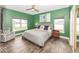 Bedroom with green walls, light colored carpet, ceiling fan, and natural light at 694 N Sobota Way, Trafalgar, IN 46181