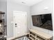Bright entryway featuring a white door with glass panels, a mounted TV, and a wooden bench at 694 N Sobota Way, Trafalgar, IN 46181