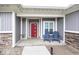 Inviting front porch with two blue Adirondack chairs and a red front door at 694 N Sobota Way, Trafalgar, IN 46181