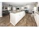 Open-concept kitchen featuring an island with granite countertop and views to living area at 694 N Sobota Way, Trafalgar, IN 46181