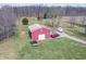 Aerial view of the property featuring a red barn, gravel driveway, and grassy area at 7212 E Rocklane Rd, Needham, IN 46162