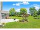Expansive backyard with a stone patio, lush lawn, and mature landscaping at 7251 Birch Leaf Dr, Indianapolis, IN 46259