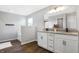Bathroom featuring a double vanity with granite counters, wood floor, and separate tub at 7251 Birch Leaf Dr, Indianapolis, IN 46259