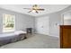 Bedroom featuring gray walls, carpeted floors, a ceiling fan, and natural light from the large window at 7251 Birch Leaf Dr, Indianapolis, IN 46259