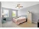 Cozy bedroom features plush carpet, a ceiling fan, and soothing gray walls, with great natural light from the two windows at 7251 Birch Leaf Dr, Indianapolis, IN 46259