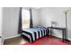Bright bedroom with a blue striped bed, a large window, and a functional black desk at 7251 Birch Leaf Dr, Indianapolis, IN 46259