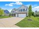 Charming home featuring a manicured lawn and long concrete driveway leading to a two car garage at 7251 Birch Leaf Dr, Indianapolis, IN 46259