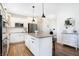 Spacious kitchen featuring white cabinets, subway tile backsplash, island with seating, and shiplap accent wall at 7251 Birch Leaf Dr, Indianapolis, IN 46259