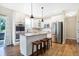 Modern kitchen with stainless steel appliances, white cabinets, island with seating, and wood floors at 7251 Birch Leaf Dr, Indianapolis, IN 46259