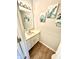 Cozy half bathroom with tropical themed artwork and laminate wood floor at 8030 Windham Lake Way, Indianapolis, IN 46214