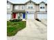 Exterior view of townhomes with colorful front doors and well-maintained lawns on a sunny day at 8030 Windham Lake Way, Indianapolis, IN 46214