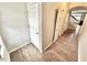 Inviting hallway with wood floors, a staircase, and white doors for storage and access at 8030 Windham Lake Way, Indianapolis, IN 46214
