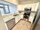 Modern kitchen with stainless steel appliances, white cabinetry, and granite countertops, and view to living room at 8030 Windham Lake Way, Indianapolis, IN 46214