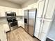 Kitchen featuring white cabinets, stainless steel appliances, and hardwood flooring at 8030 Windham Lake Way, Indianapolis, IN 46214