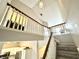 Carpeted staircase with white railing leads to a landing with natural light and access to other rooms at 8030 Windham Lake Way, Indianapolis, IN 46214