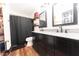 Beautiful bathroom featuring a double vanity with granite countertop, black fixtures, and wood-look laminate flooring at 839 Bough St, Whiteland, IN 46184