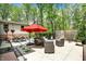 Outdoor patio with seating, dining under red umbrella, and lush surroundings, ideal for relaxing and entertaining at 8990 Pickwick Dr, Indianapolis, IN 46260