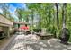 Outdoor patio features a spa, outdoor seating, and privacy fence with view of lush, mature trees at 8990 Pickwick Dr, Indianapolis, IN 46260