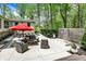 Outdoor patio with plush seating, dining area under a red umbrella, and privacy fence, surrounded by greenery at 8990 Pickwick Dr, Indianapolis, IN 46260