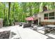 Beautiful backyard with a stone patio, seating area, and views of the surrounding forest at 8990 Pickwick Dr, Indianapolis, IN 46260