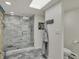 Bright bathroom featuring a glass enclosed shower with marble tile and a large skylight at 8990 Pickwick Dr, Indianapolis, IN 46260