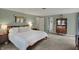 Large bedroom features neutral carpet, light green paint, and access to the bathroom at 8990 Pickwick Dr, Indianapolis, IN 46260
