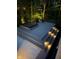 Multi-tiered deck with inset lights, featuring a hot tub and lounging area surrounded by a wooded landscape at 8990 Pickwick Dr, Indianapolis, IN 46260