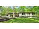 Charming home featuring a well-manicured lawn and beautiful landscaping, complemented by a tree-lined property at 8990 Pickwick Dr, Indianapolis, IN 46260
