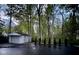 Detached garage with a freshly paved driveway and mature trees at 8990 Pickwick Dr, Indianapolis, IN 46260