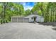 Spacious three-car garage with ample parking and a paved driveway surrounded by lush trees at 8990 Pickwick Dr, Indianapolis, IN 46260