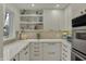 Bright kitchen features white cabinets, modern appliances, and floating shelves with decorative items at 8990 Pickwick Dr, Indianapolis, IN 46260
