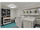 Bright laundry room featuring modern washer and dryer, storage shelves, and natural light at 8990 Pickwick Dr, Indianapolis, IN 46260