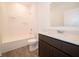 Modern bathroom with dark cabinets, large mirror, tub and shower combination, and wood-look flooring at 915 Saddlebrook Farms Blvd, Whiteland, IN 46184