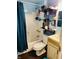 Bathroom with tiled tub, toilet, sink, and floating shelves for storage at 918 N Olney St, Indianapolis, IN 46201