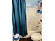Bathroom with white walls, blue shower curtain, toilet, tub, and shower fixture at 918 N Olney St, Indianapolis, IN 46201