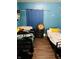 Cozy bedroom featuring two twin beds, hardwood floors, and blue colored walls at 918 N Olney St, Indianapolis, IN 46201