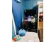 Bedroom including twin bed, flat screen television, closet, and view into the dining room at 918 N Olney St, Indianapolis, IN 46201