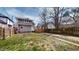 A fenced backyard that features a two-story home, a small set of stairs, and a concrete driveway on the right at 926 N Dearborn St, Indianapolis, IN 46201