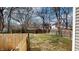 Fenced backyard that features a gate with a small concrete slab and several bare trees in the surrounding area at 926 N Dearborn St, Indianapolis, IN 46201
