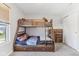 Bright bedroom showcases a wooden bunk bed, complemented by a dresser and a window with neighborhood views at 951 Brookstone Dr, Franklin, IN 46131